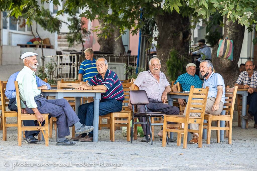 A couple of men sitting in front of a tearoom in Turkey