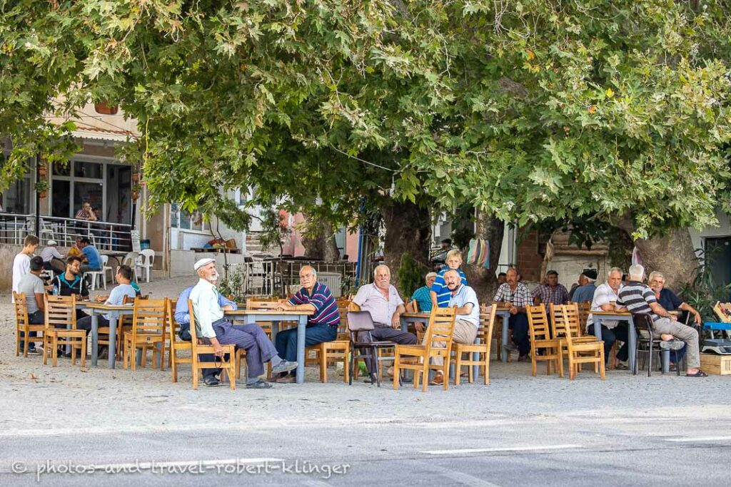 A couple of men sitting in front of a tearoom in Turkey