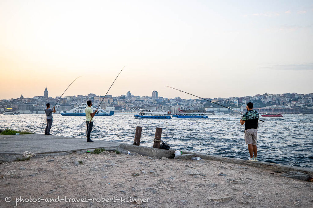 Three fisherman on the shore of the Bosphorus in Istanbul