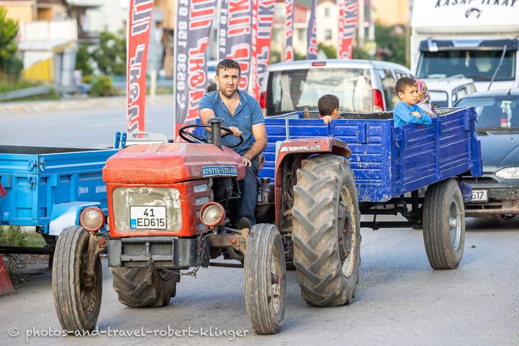 A man on a tractor and his family in the trailer