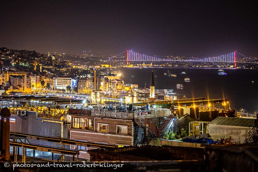 The Fatih Sultan Mehmet Bridge in Istanbul and some roof top cafes in the foreground