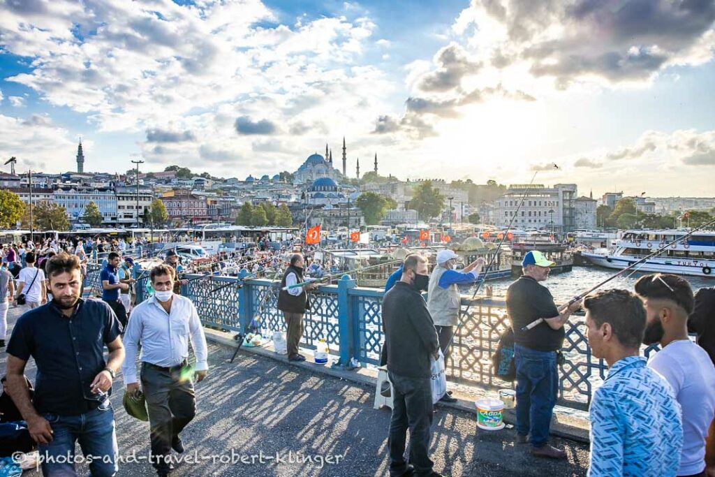 People fishing from and crossing Atatürk bridge in Istanbul