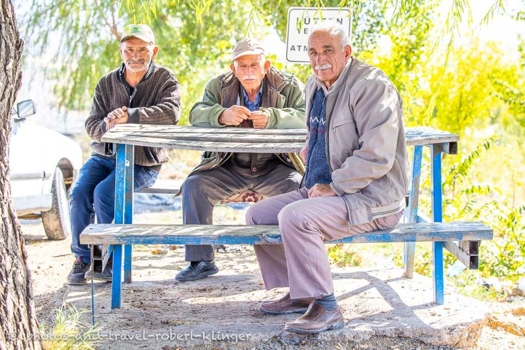 Three men sitting on a bench along the road in Cappadocia
