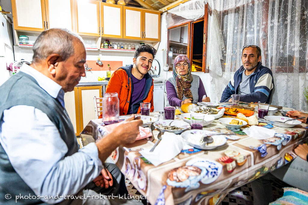 Three turkish men and a woman having dinner in a village in Turkey