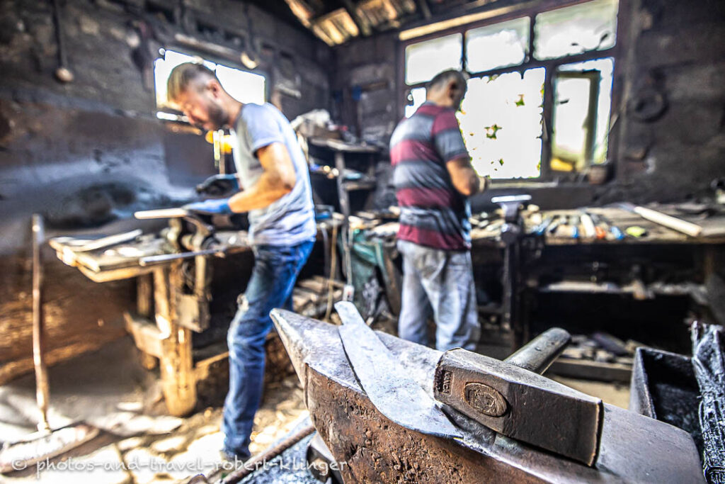 Two forgers at work in their workshop