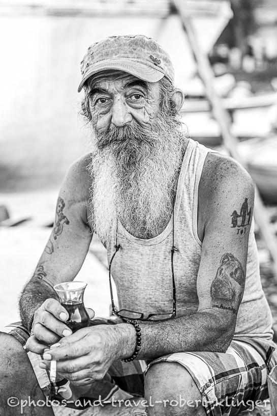 A fisherman smoking a cigarette and having tea in Amasra in Turkey