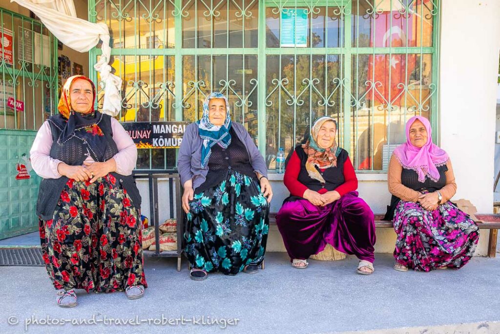 Three old woman sitting in front of a store in the Ihlara Valley