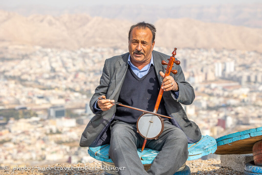 A man from Iraq playing an instrument above Dohuk