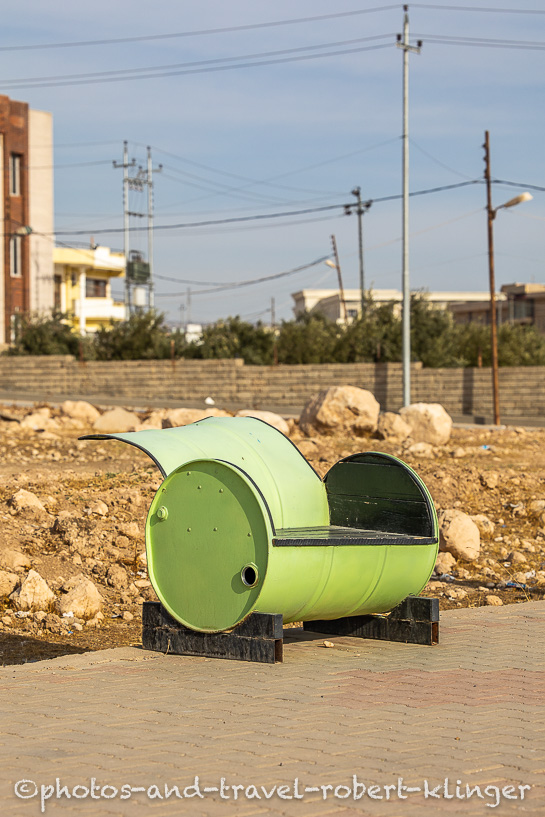 A green bench which was made from a oil barrel, Iraq