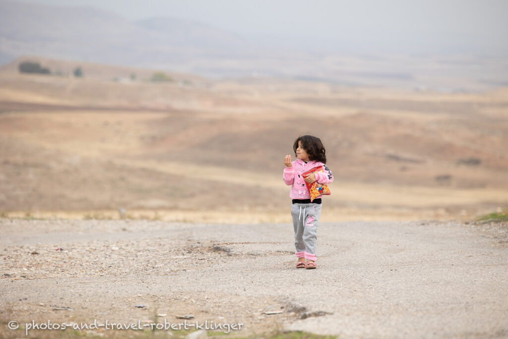 An Iraqi girl walking home with a bagful of chips