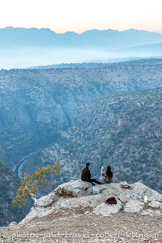 A young Iraqi couple is sitting high above a canyon in northern Iraq