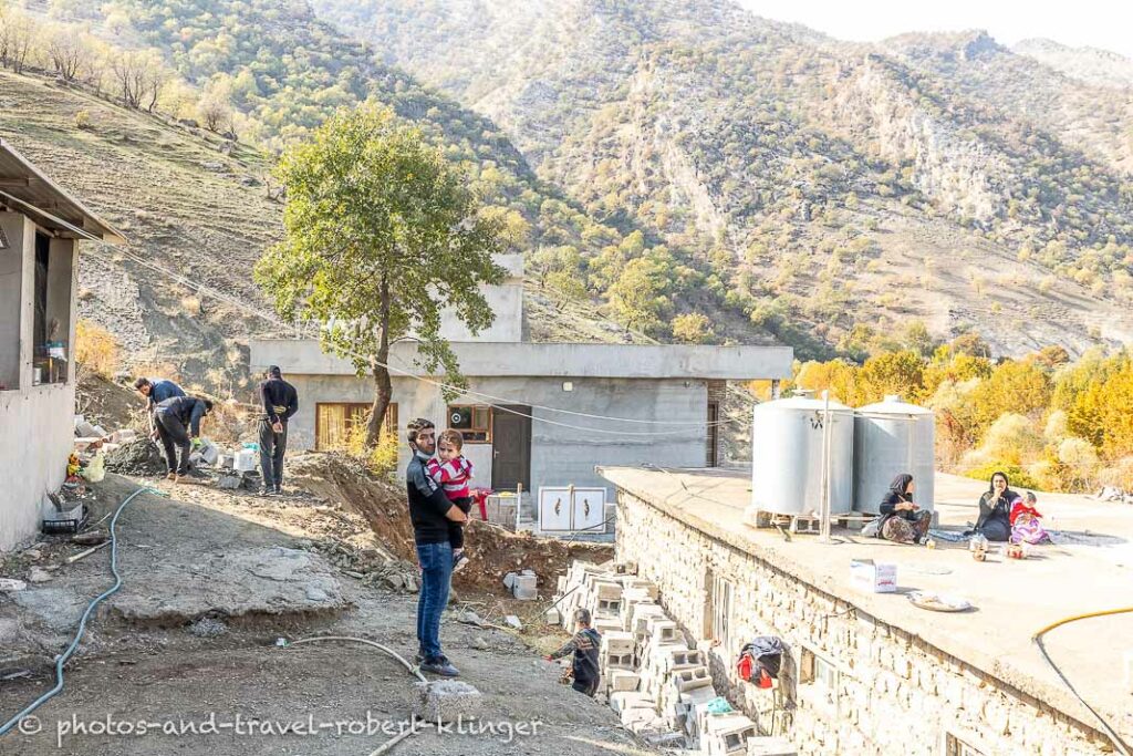 Men working on a construction site in Kurdistan and two women having a rest