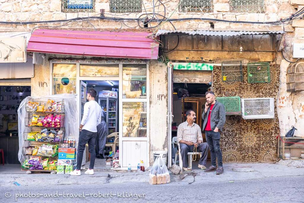 Three men in front of a shop in Akre, Kurdistan