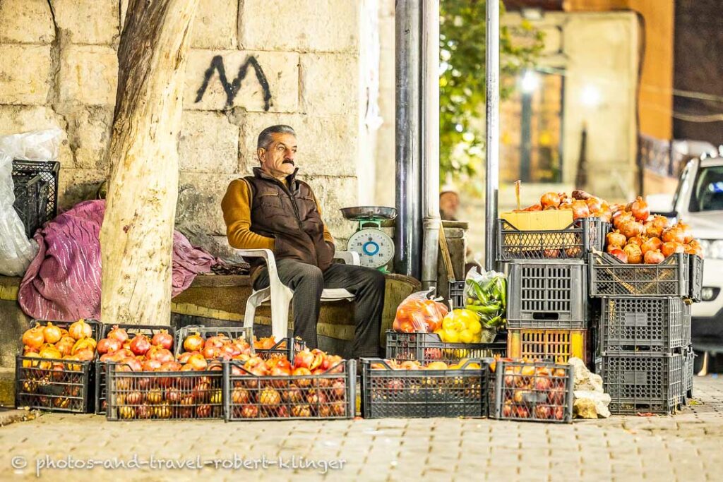A man selling fruits on the market in Akre