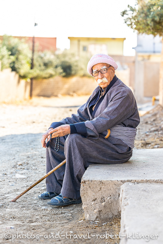 A old man sitting on a house entrance in Alqosh, Kurdistan