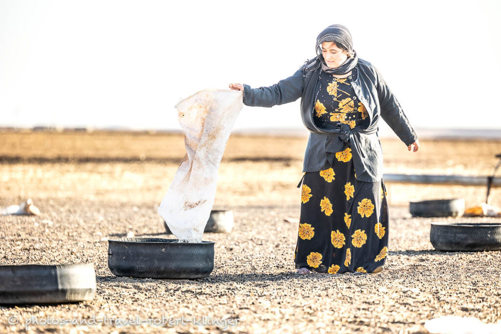 A kurdish woman preparing food for the goat