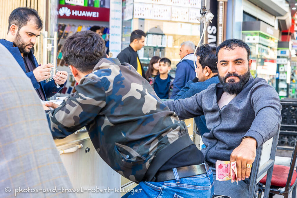 A kurdish man in Erbil sitting in front of his shop in Erbil and is selling smarphones