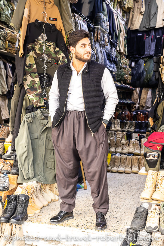 A young man in traditional kurdish clothes in his shop in Erbil
