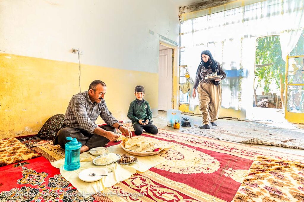 A kurdish family is having lunch in their living room in a village at lake Dukan, Kurdistan