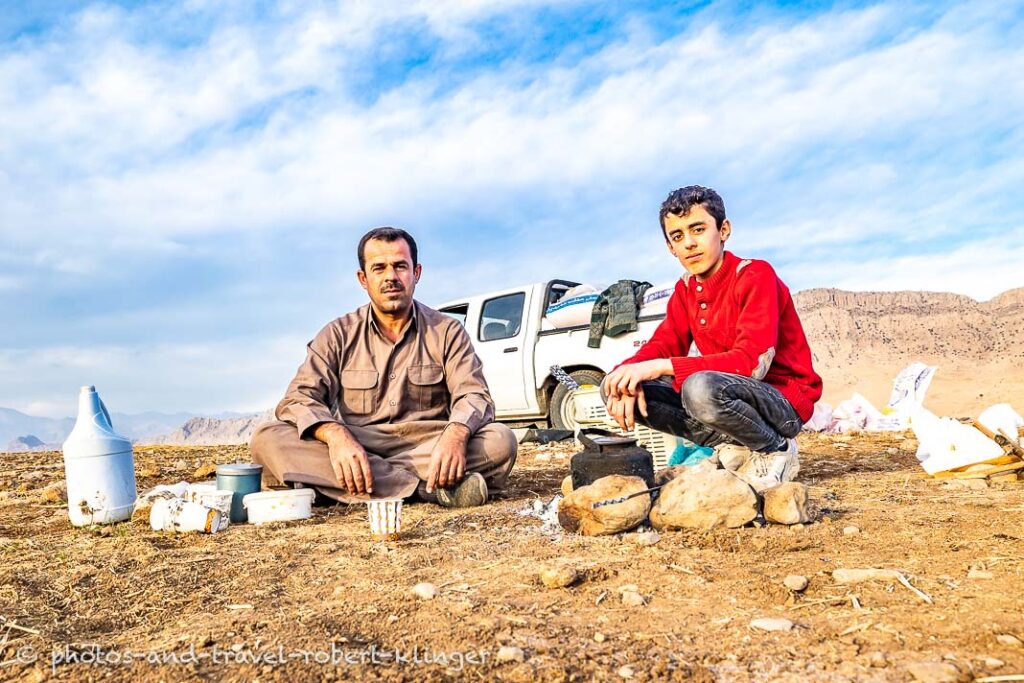 A father and his son having tea during agricultural work on a field