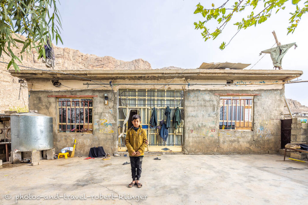 A kurdish boy in front of his house in a village at Dukan Lake