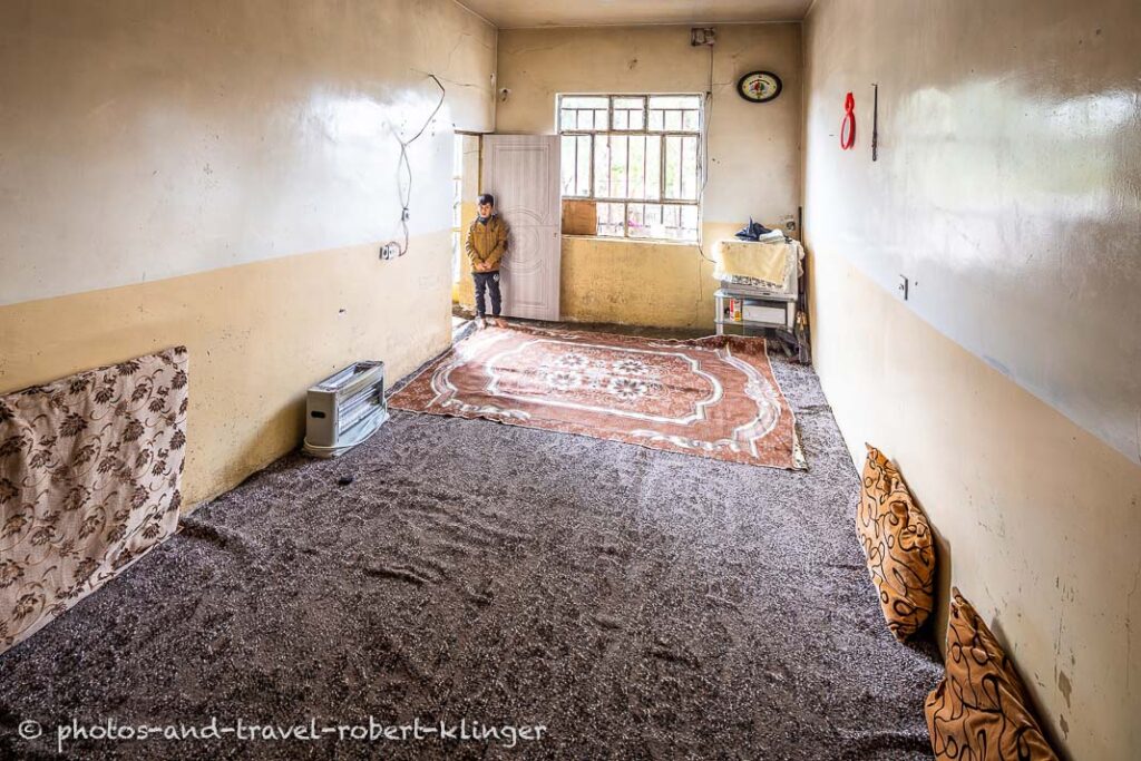 A boy standing by the door of his bedroom in Kurdistan