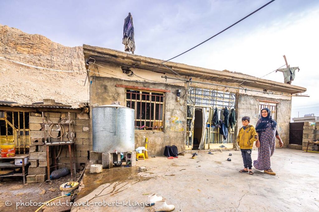 A kurdish boy and his mother in front of their house in Kurdistan, Iraq