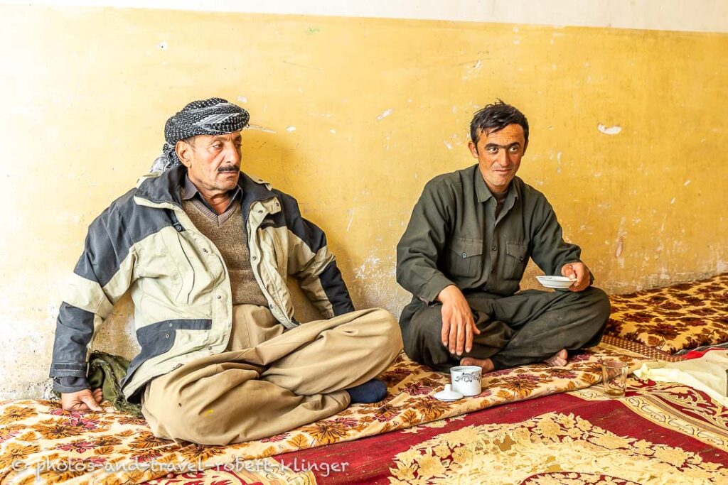 Two kurdish goat farmers are having tea in their living room in a village at lake Dukan, Kurdistan