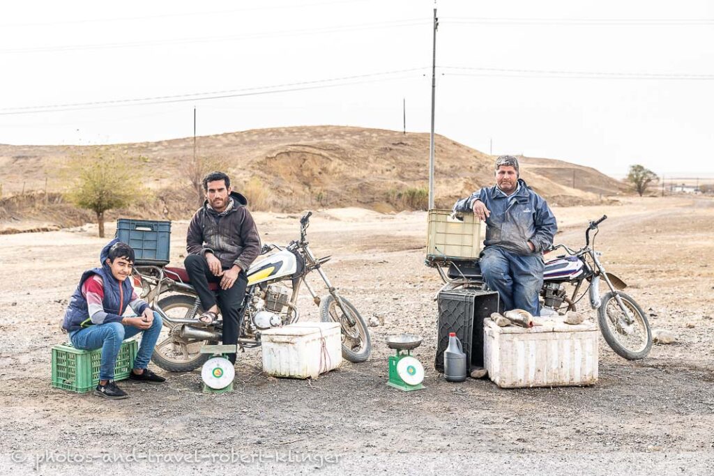 Three men are selling fish next to the road in Kurdistan