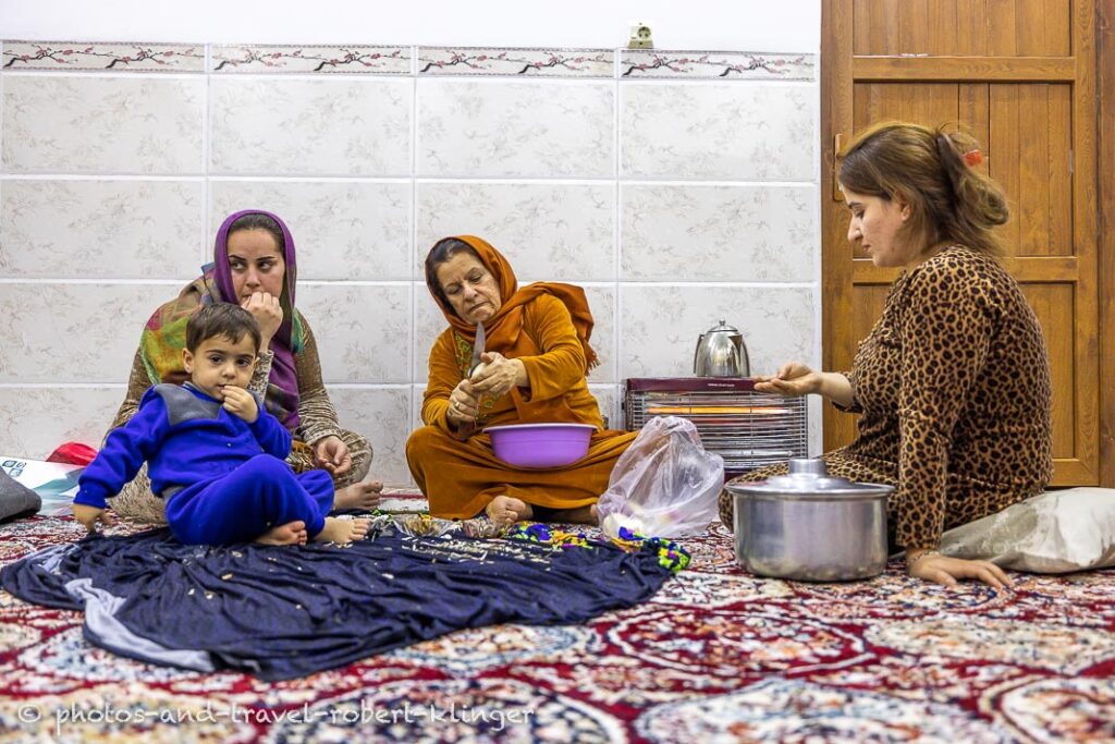Three kurdish woman and a boy in their house preparing food