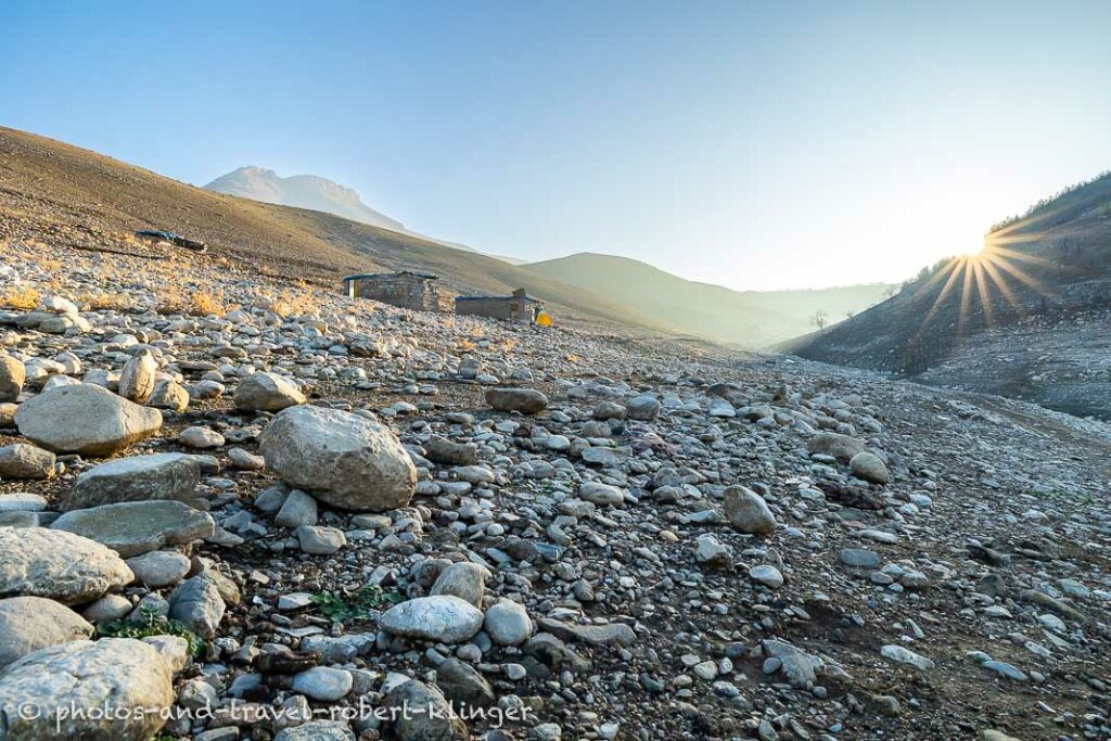 The sun is rising over the mountains around Lake Dukan