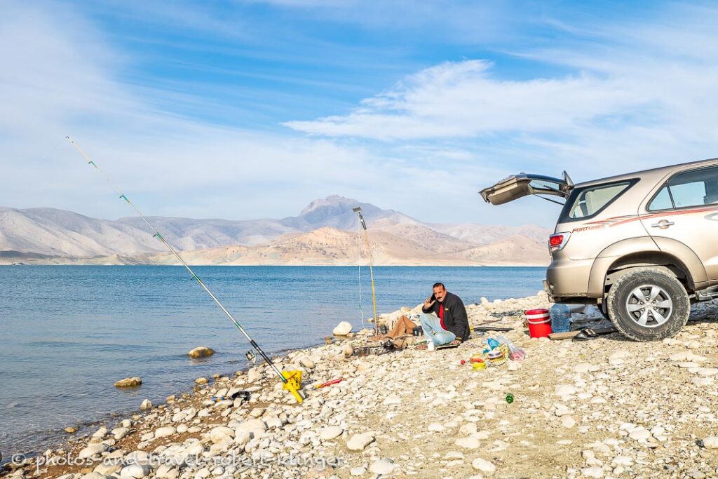 A fisherman fishing with rods at lake Dukan