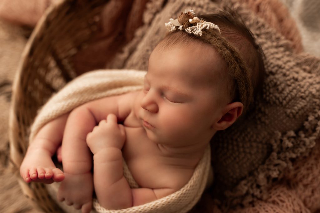 nyföddfotografering i västerås med bebisen poserande