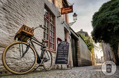 A bicycle sits by the oldest cafe in town (est 1515) at sunset on a sidestreet of Bruges Belgium. Photo by Photo Tour Brugge.