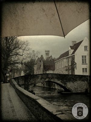 An umbrella covers from the rain on a stretch of canals in Brugge Belgium. Photo by Photo Tour Brugge.