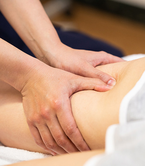 Massage Therapieanwendung Physiotherapeut massiert Patient am Oberschenkel