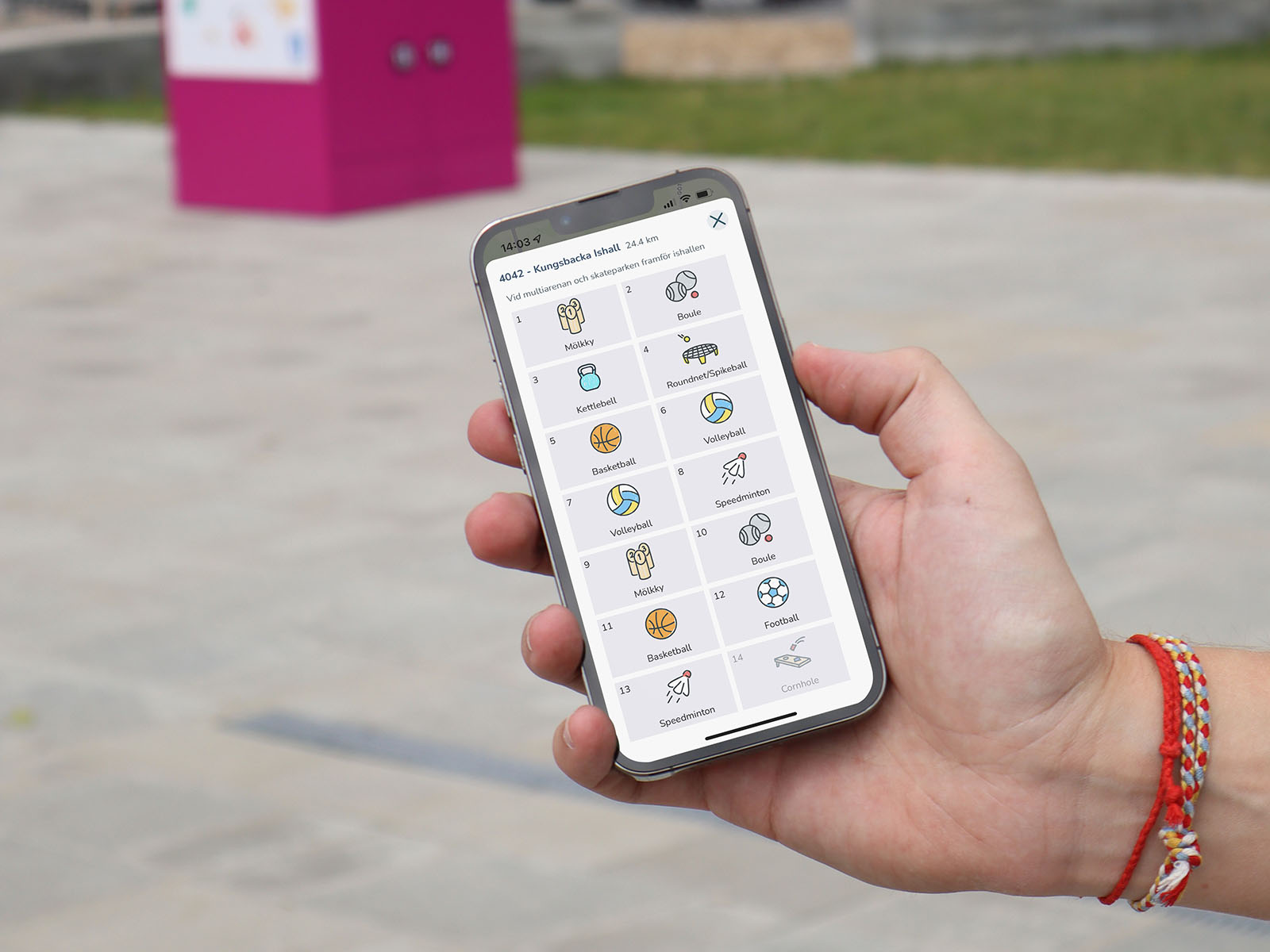 En hand som visar en app där man kan se vilka aktiviteter som finns i en rosa box