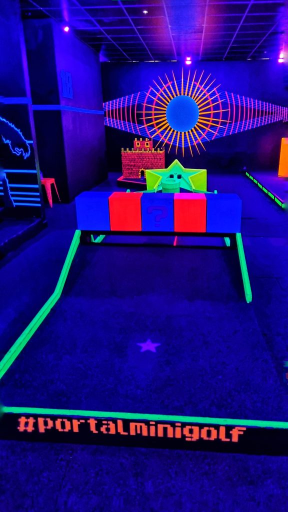 Portal mini golf with its neon lights and Mario themed round.