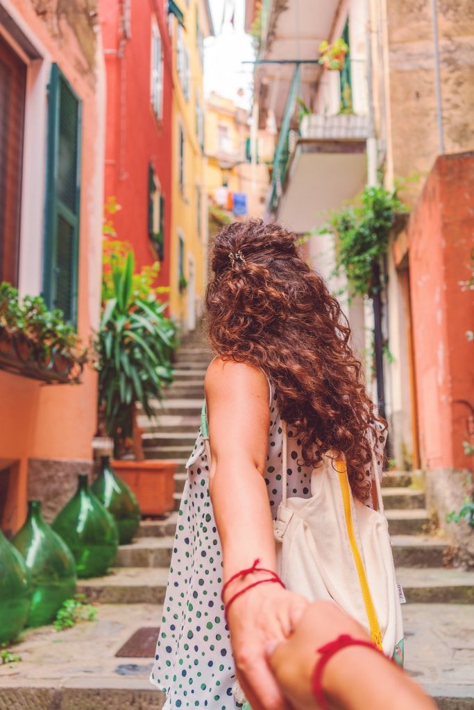 Girl leading her partner walking around an old town. 