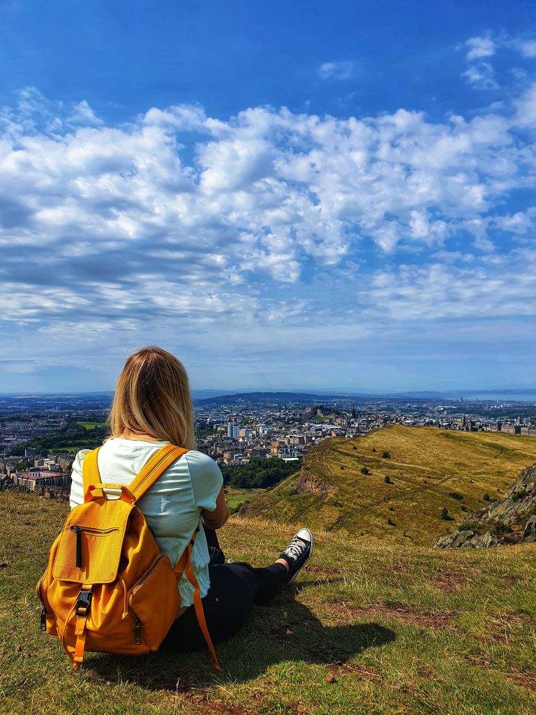 Amy enjoying the view from Arthur's Seat during her first solo travel trip to Edinburgh.