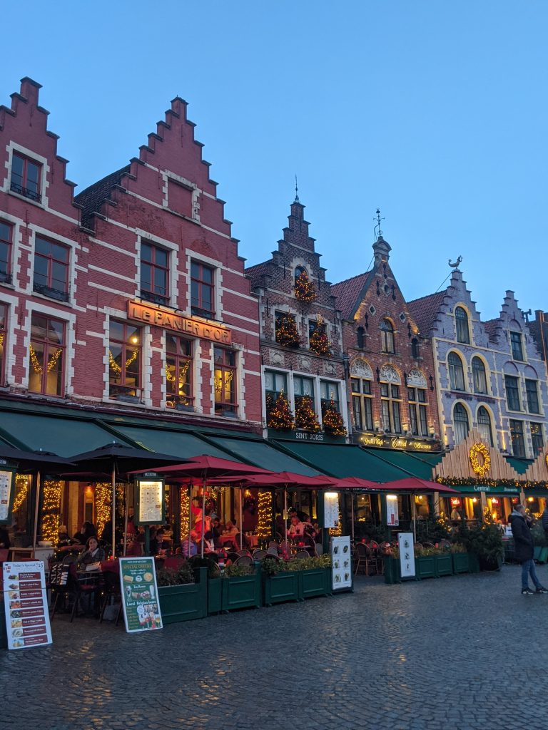 The restaurants in Bruges look a little like what you would imagine for the Christmas markets. The restaurants are all boxed with green awnings and red umbrellas.
