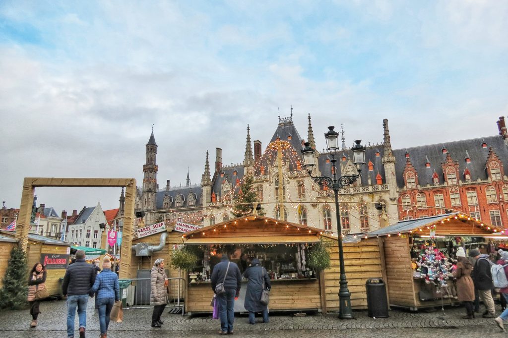 Tourists walking around the different Christmas market stalls in Bruges.