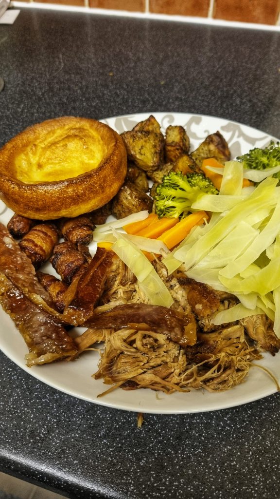 One of the roast dinners that we made at home include pigs in blankets, roast potatoes, pork, crackling, cabbage, broccoli, carrots and a yorkshire pudding.