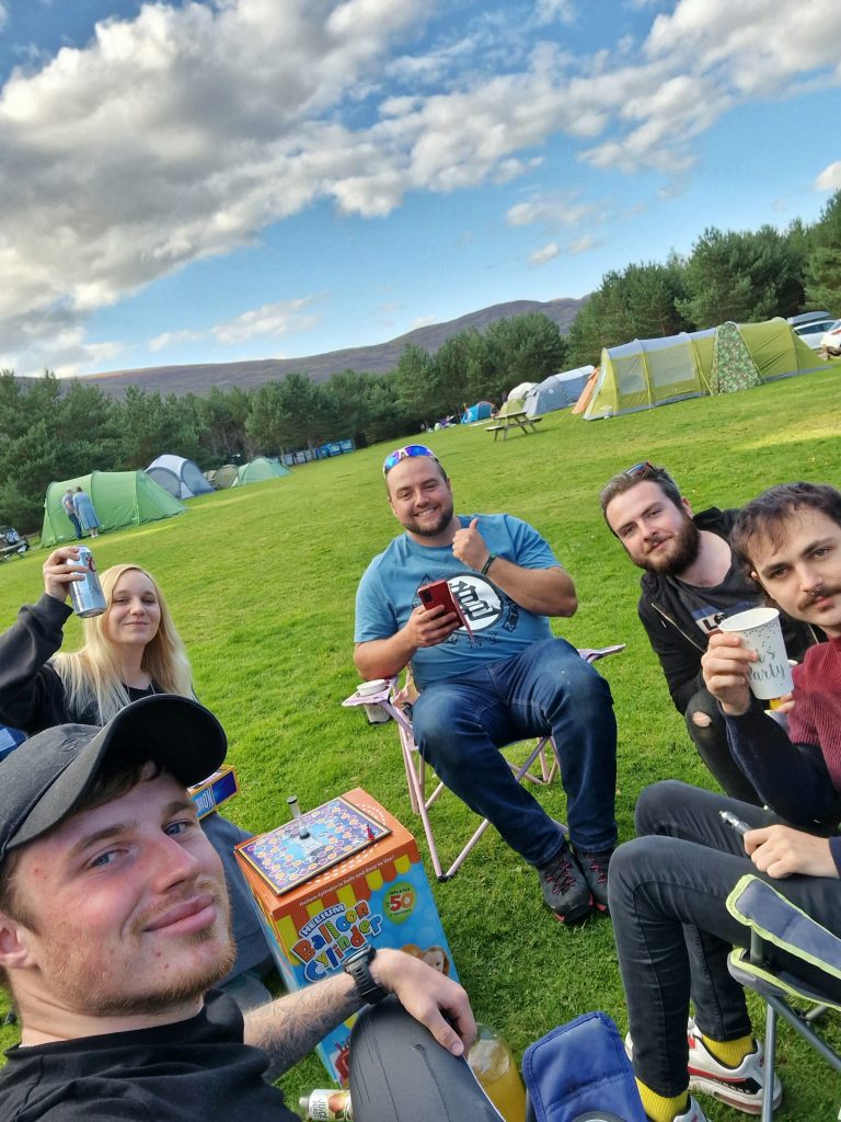 Amy, Liam and 3 of their friends toasting to an ultimate camping weekend in Aviemore.