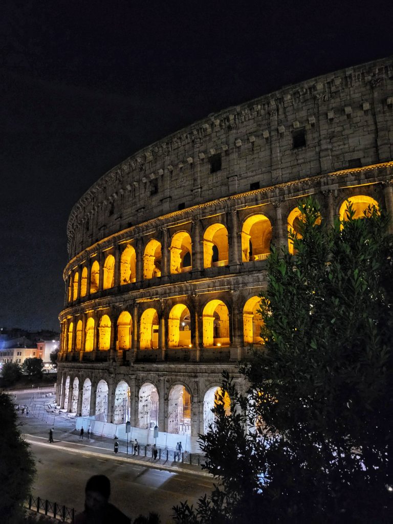 View of the colosseum at night which is one of the most romantic things to do in Rome Italy.