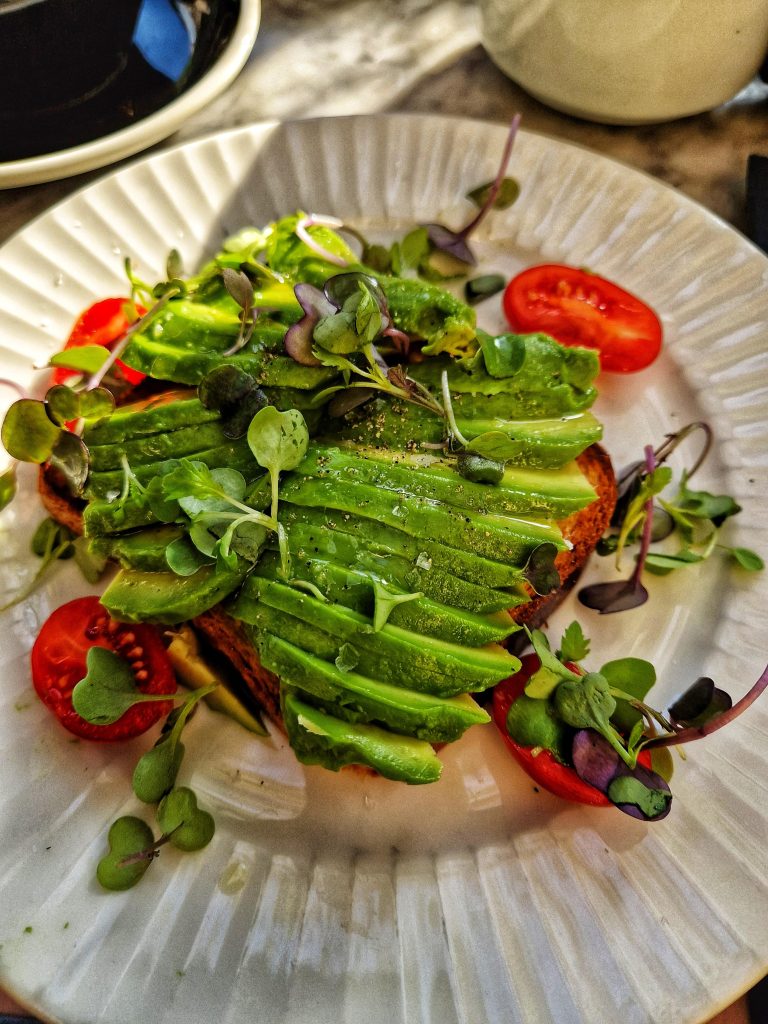 Amy likes to try different versions of avocado toast when she is travelling so that she can see which one is best. This avocado toast included cherry tomatoes and a garnish which was very yummy.