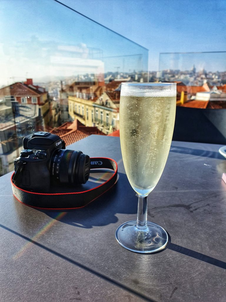 Photo of our camera with a glass of Prosecco taken at a rooftop bar in Lisbon.