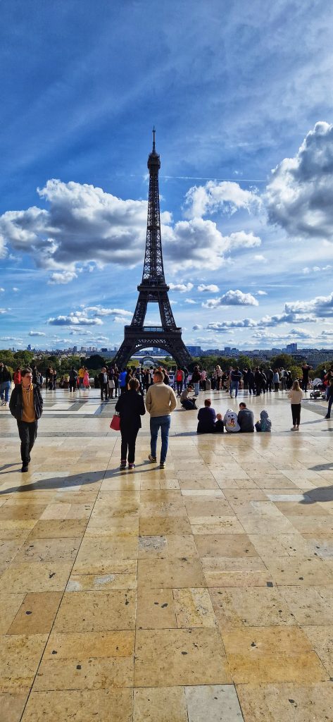 Eiffel tower with crowds of people enjoying it's beauty.