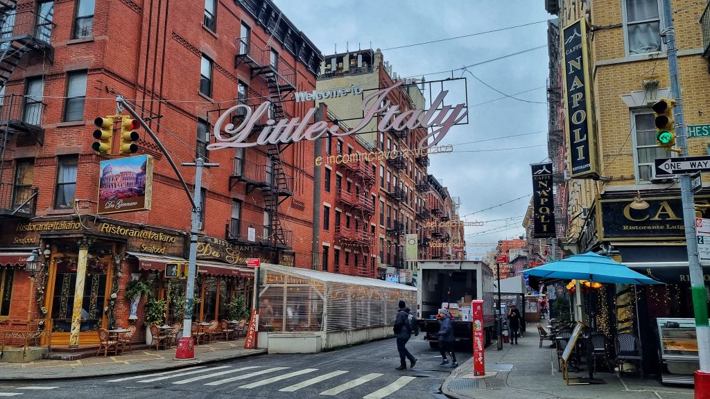 Sign for Little Italy with some Italian restaurants in view.