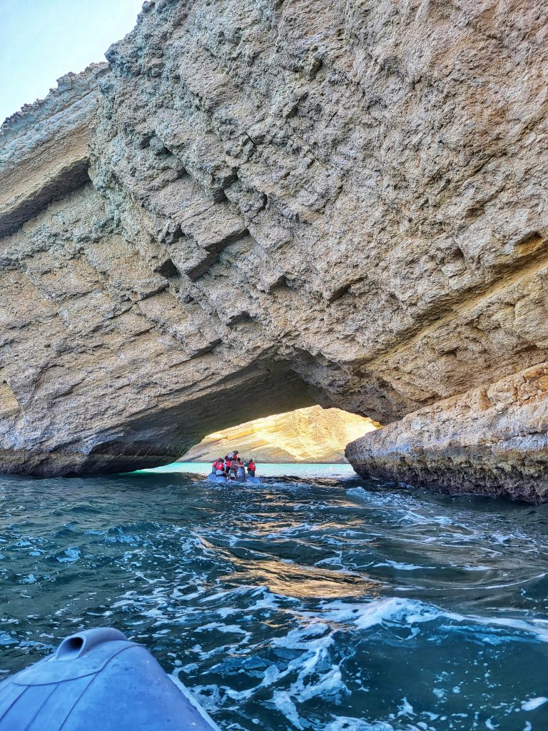 Going out in Oman on the boats was one of the highlights of Liam's time here. In this image you can see the boats going underneath a cave archway with some bright sun awaiting them on the other side.